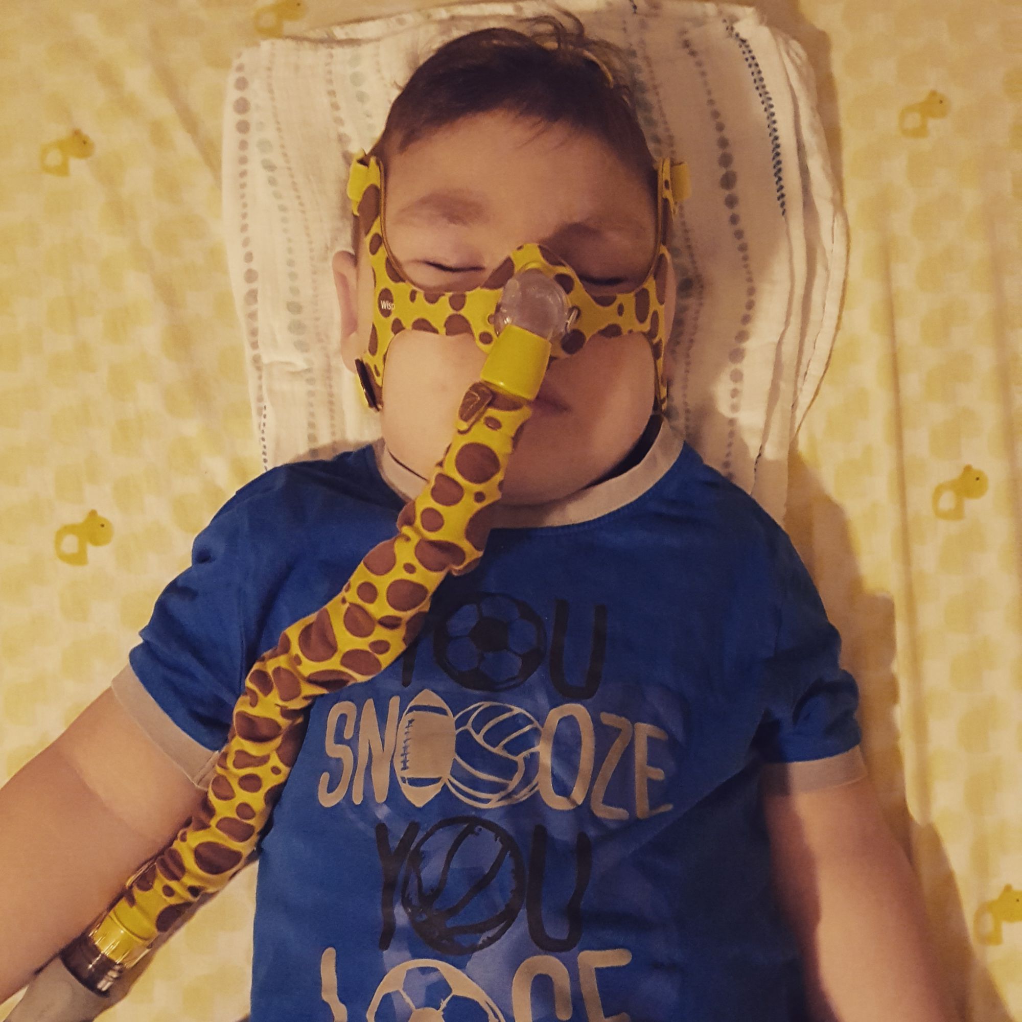 Félip sleeping with his BiPAP machine